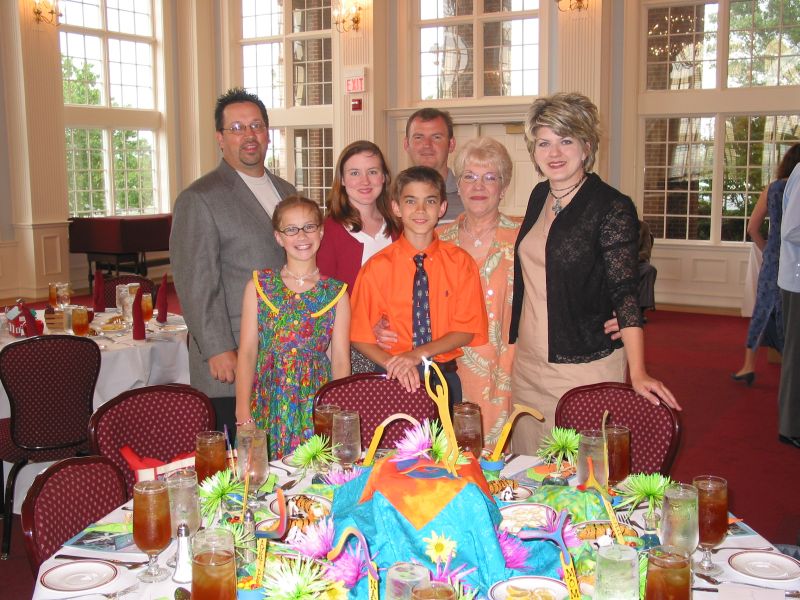 Bruce, Holly, Amanda, Andrew, Joe, Loretta, and Michelle standing behind the boomerang banquet table.